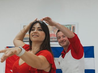 Nikoletta and Stephen dancing in front of a Cuban flag
